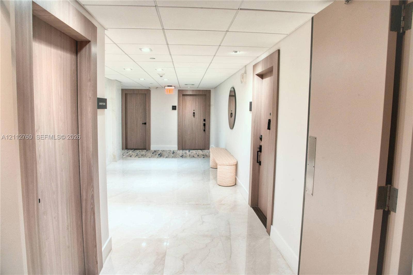 5825 Collins Avenue, #11H, Miami Beach, FL 33140 Interior hallway featuring polished stone-finish flooring, recessed ceiling lighting, and wood-finish door frames