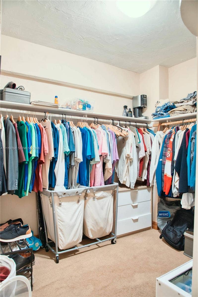 5825 Collins Avenue, #11H, Miami Beach, FL 33140 Walk-in closet featuring extensive overhead shelving, a built-in three-drawer chest, and dual-tier garment hanging rods