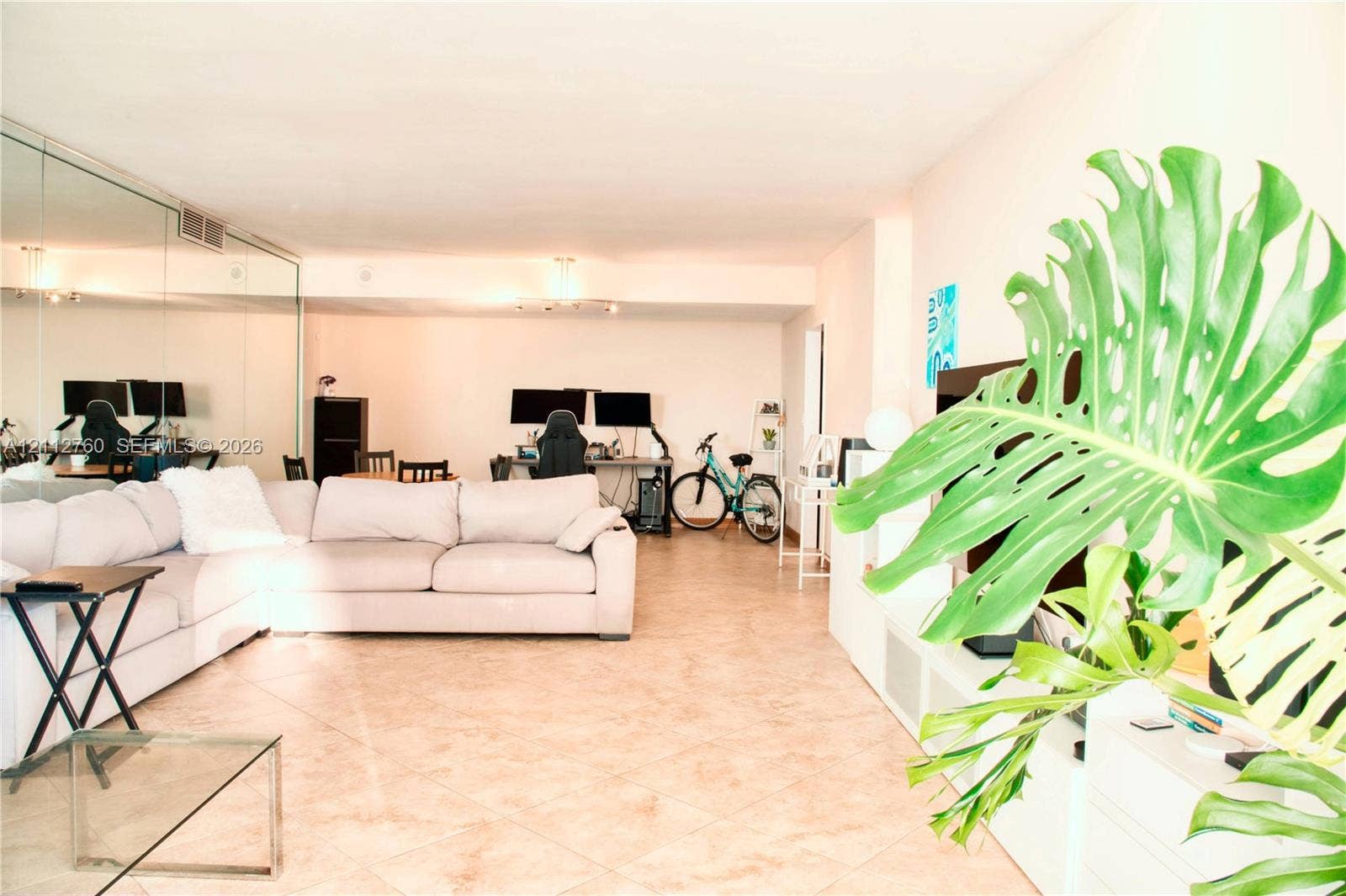 5825 Collins Avenue, #11H, Miami Beach, FL 33140 Open floor plan featuring large-format ceramic tile flooring and floor-to-ceiling mirror wall paneling