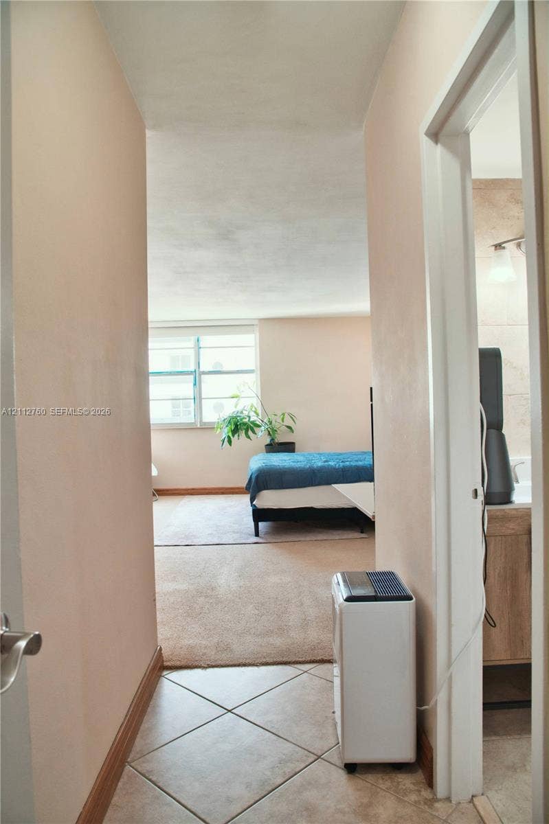 5825 Collins Avenue, #11H, Miami Beach, FL 33140 Tile flooring, wall-to-wall carpeting, and a multi-pane window