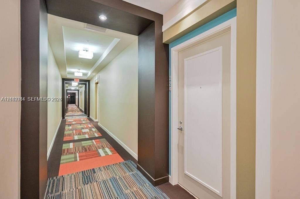 550 Okeechobee Boulevard, #224, West Palm Beach, West Palm Beach, FL 33401 Interior corridor featuring recessed ceiling lighting, multi-tonal patterned carpeting, and recessed door entryways framed by dark accent walls