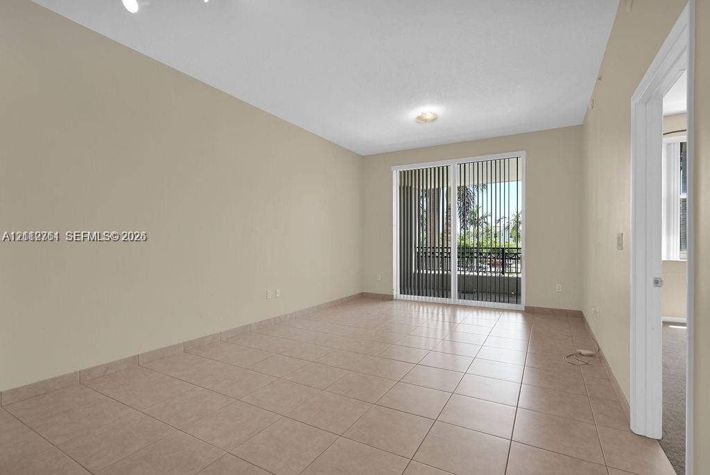 550 Okeechobee Boulevard, #224, West Palm Beach, West Palm Beach, FL 33401 Interior space featuring neutral-toned wall paint, ceramic tile flooring, and a sliding glass door with vertical blinds providing exterior access