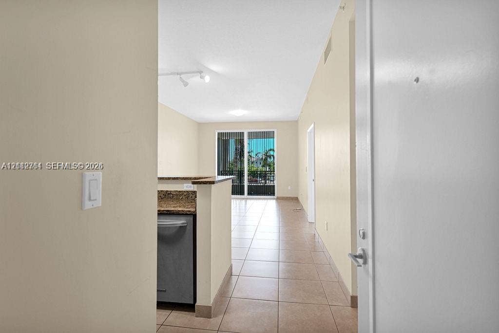 550 Okeechobee Boulevard, #224, West Palm Beach, West Palm Beach, FL 33401 Interior featuring ceramic tile flooring, stone-finish countertops, stainless steel dishwasher, track lighting, and sliding glass doors