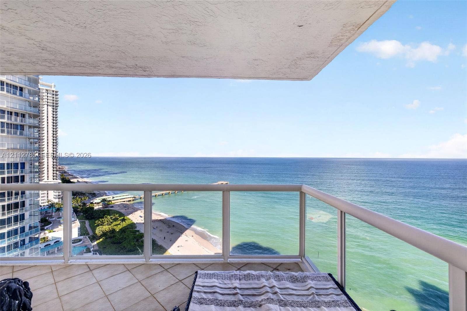 16425 Collins Avenue, #2016, Sunny Isles Beach, FL 33160 Covered balcony featuring tile flooring and a glass-paneled railing
