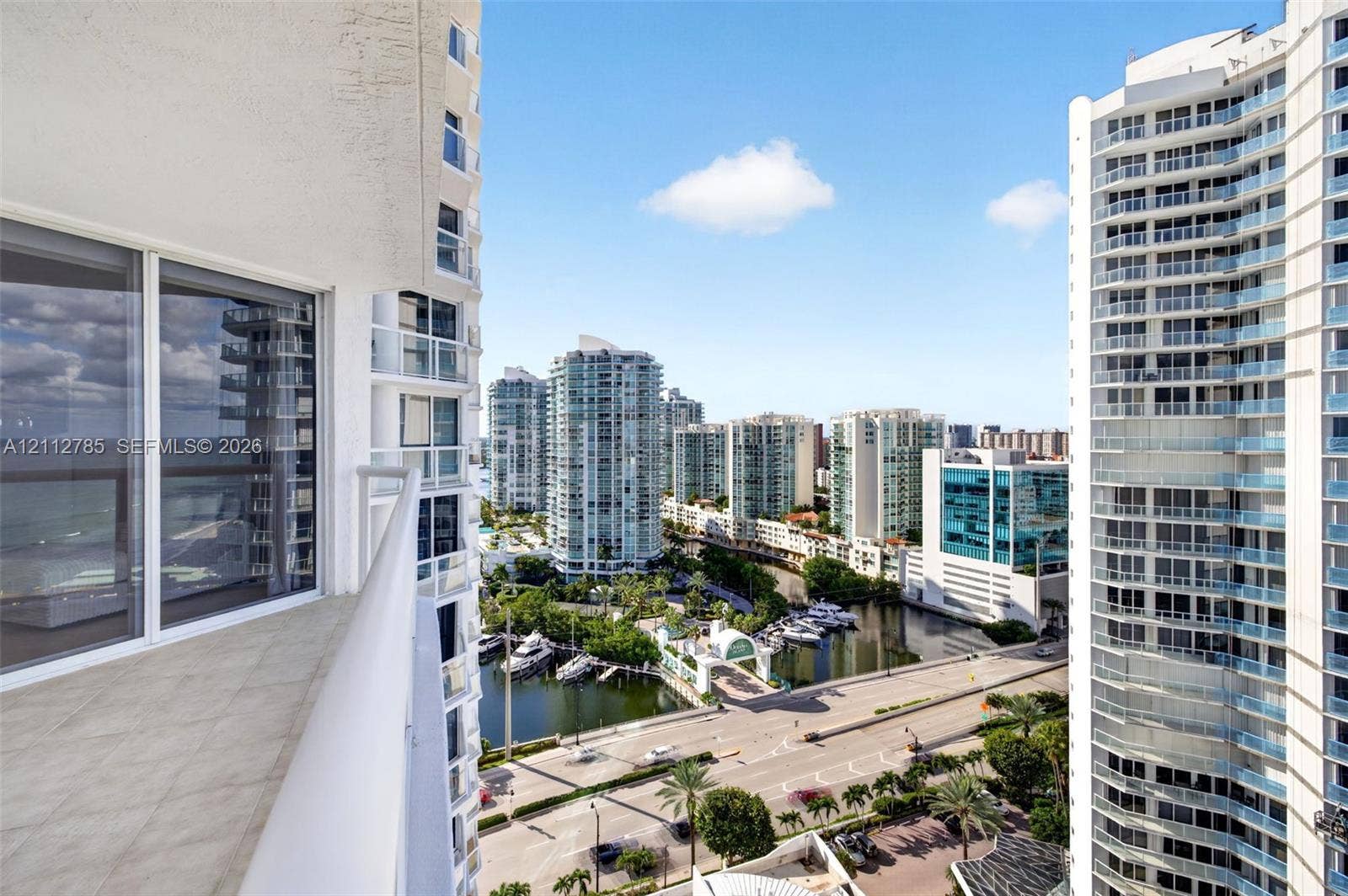 16425 Collins Avenue, #2016, Sunny Isles Beach, FL 33160 Private balcony with tile flooring and glass railings featuring panoramic urban and waterfront exposures
