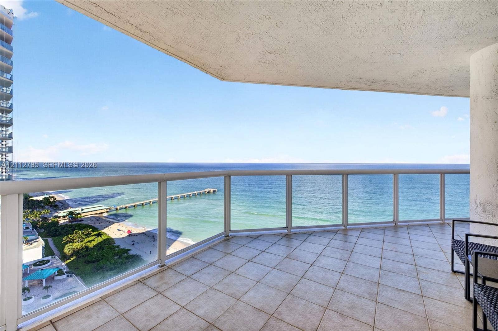 16425 Collins Avenue, #2016, Sunny Isles Beach, FL 33160 Covered balcony featuring square tile flooring and a glass railing system overlooking the oceanfront