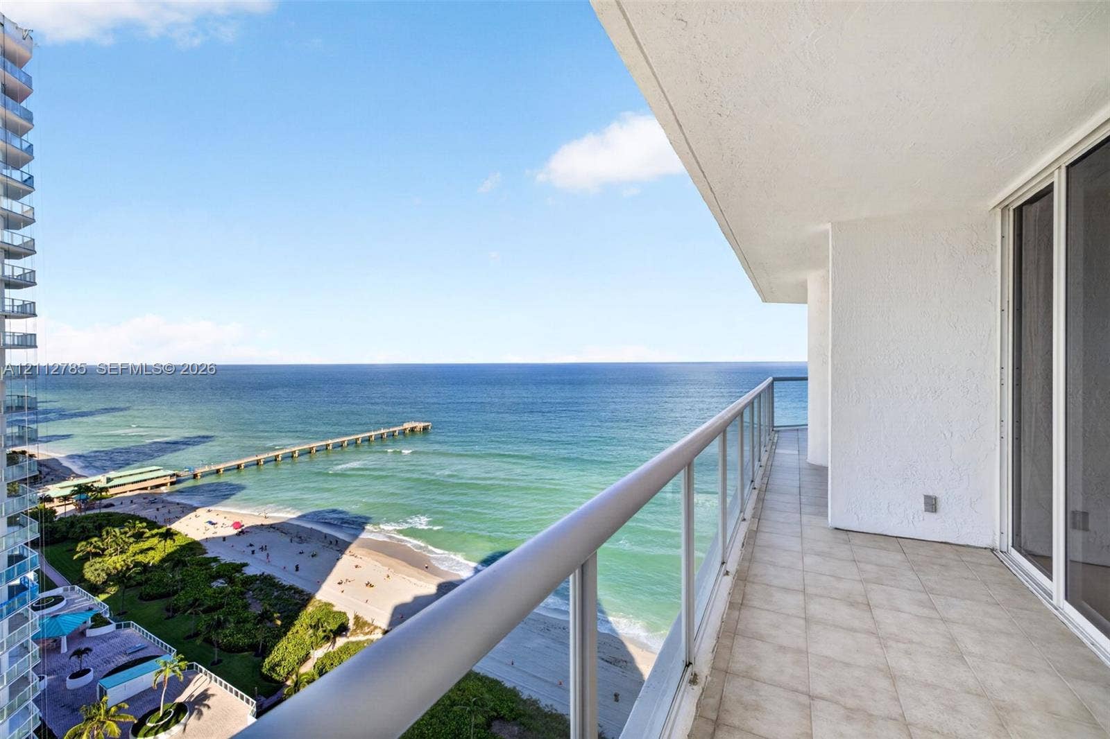 16425 Collins Avenue, #2016, Sunny Isles Beach, FL 33160 Covered balcony with light-colored floor tiling, glass panel railing, and oceanfront exposure