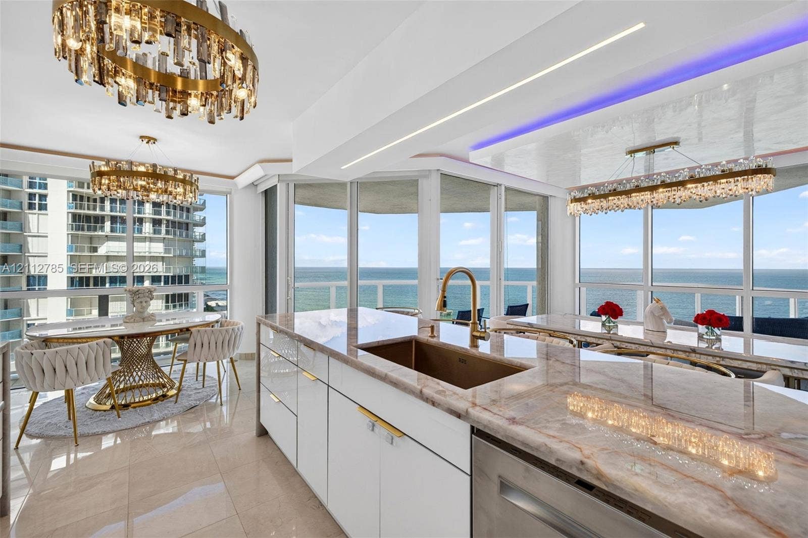 16425 Collins Avenue, #2016, Sunny Isles Beach, FL 33160 Kitchen featuring stone countertops, white flat-panel cabinetry, a metallic undermount sink with a gooseneck faucet, floor-to-ceiling glass walls, and tiered crystal chandeliers
