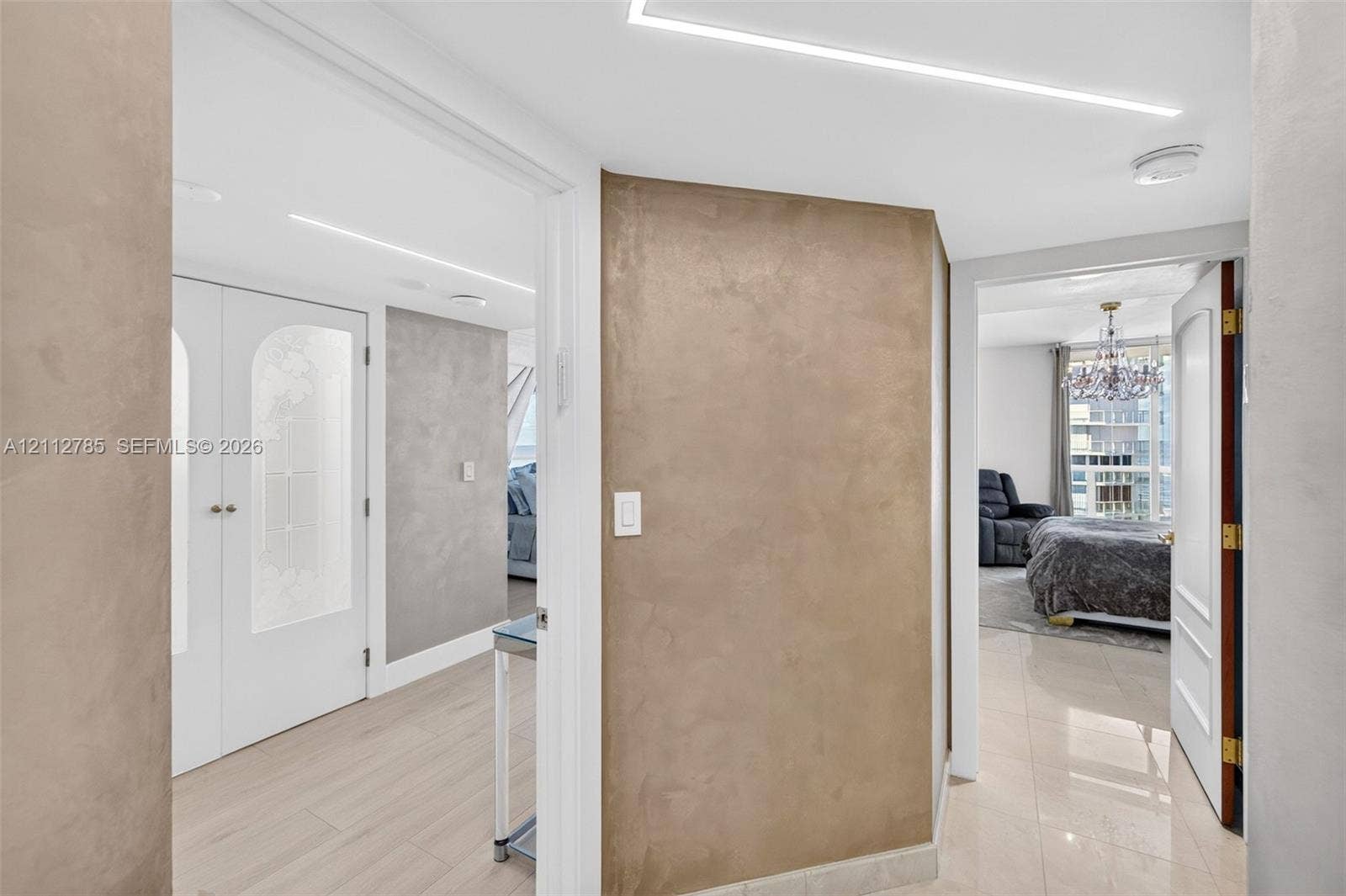 16425 Collins Avenue, #2016, Sunny Isles Beach, FL 33160 Textured plaster accent walls, recessed linear ceiling lighting, light-toned tile flooring, and interior doors featuring arched frosted glass panels
