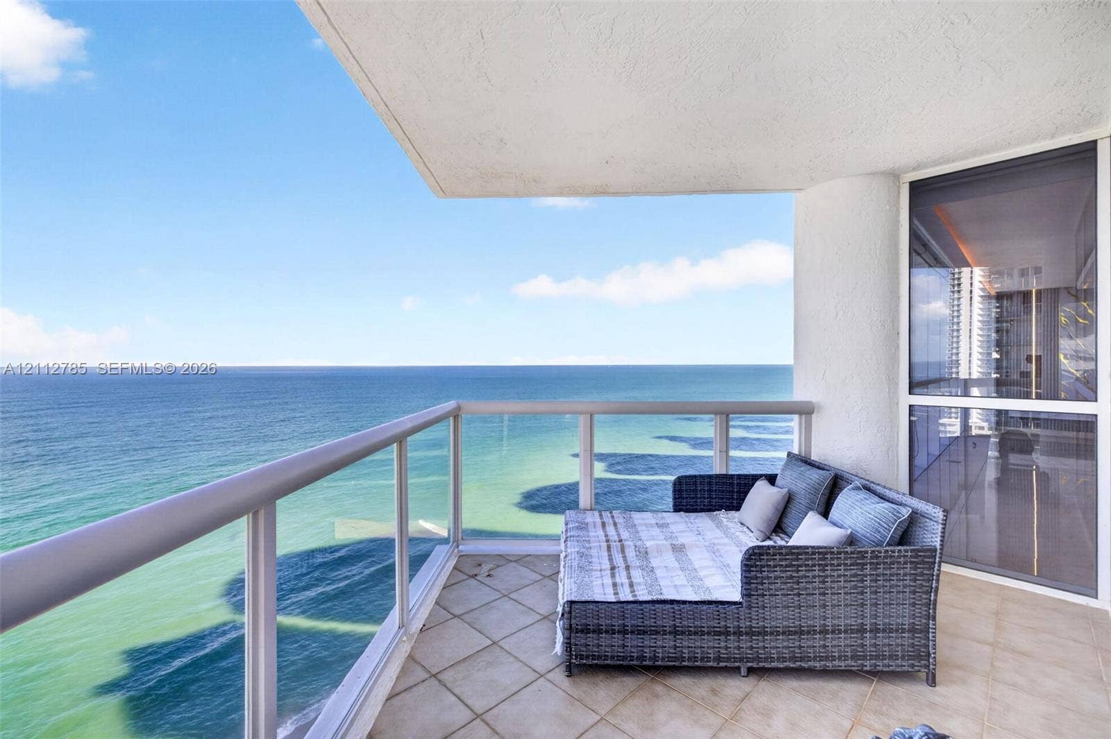 16425 Collins Avenue, #2016, Sunny Isles Beach, FL 33160 Covered balcony featuring tile flooring, glass and metal railings, and direct ocean water frontage