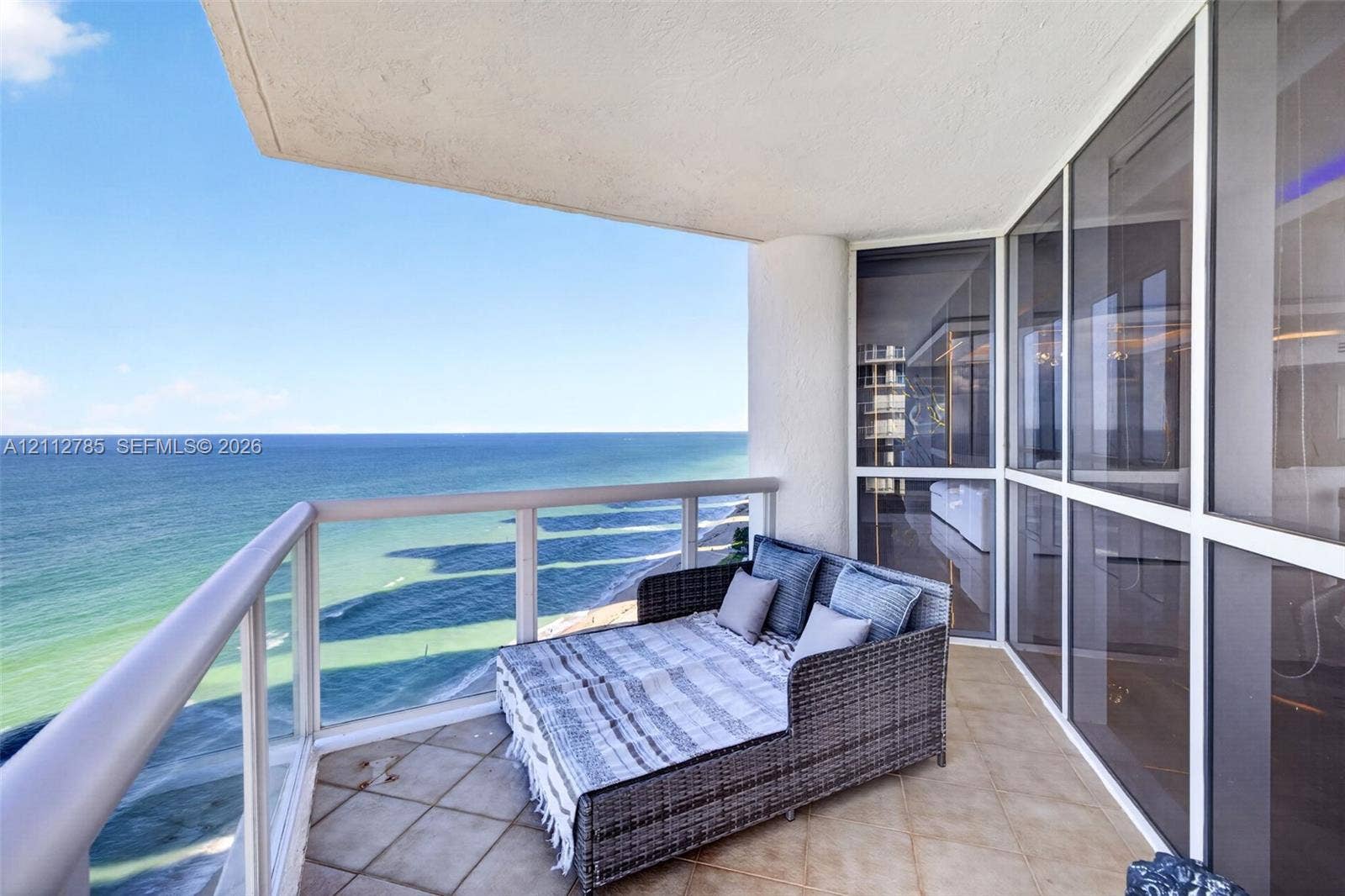 16425 Collins Avenue, #2016, Sunny Isles Beach, FL 33160 Private balcony featuring tile flooring, metal and glass railings, and floor-to-ceiling glass paneling overlooking the ocean