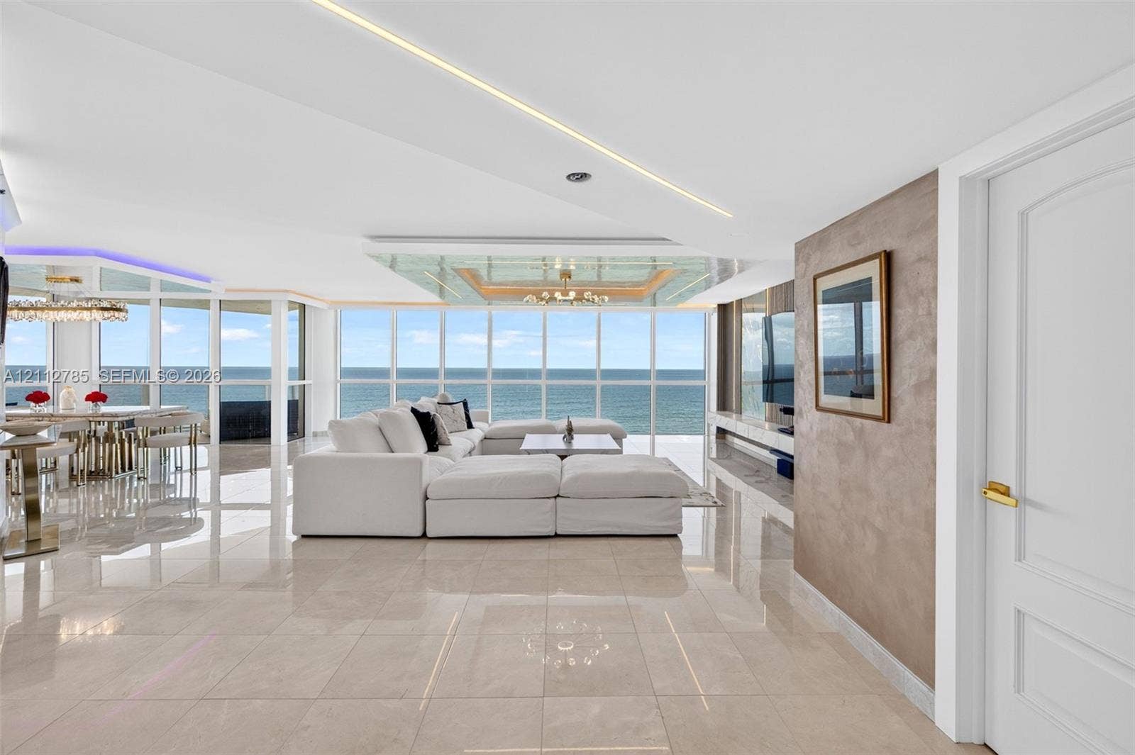 16425 Collins Avenue, #2016, Sunny Isles Beach, FL 33160 Floor-to-ceiling windows with ocean scenery, polished stone flooring, linear recessed ceiling lighting, and a custom textured accent wall