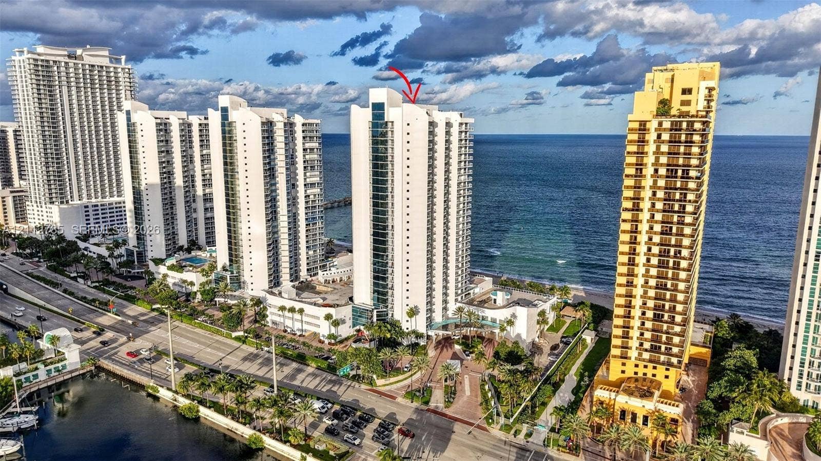 16425 Collins Avenue, #2016, Sunny Isles Beach, FL 33160 High-rise residential tower featuring a glass and concrete facade, direct ocean frontage, and a prominent position within a coastal landscape
