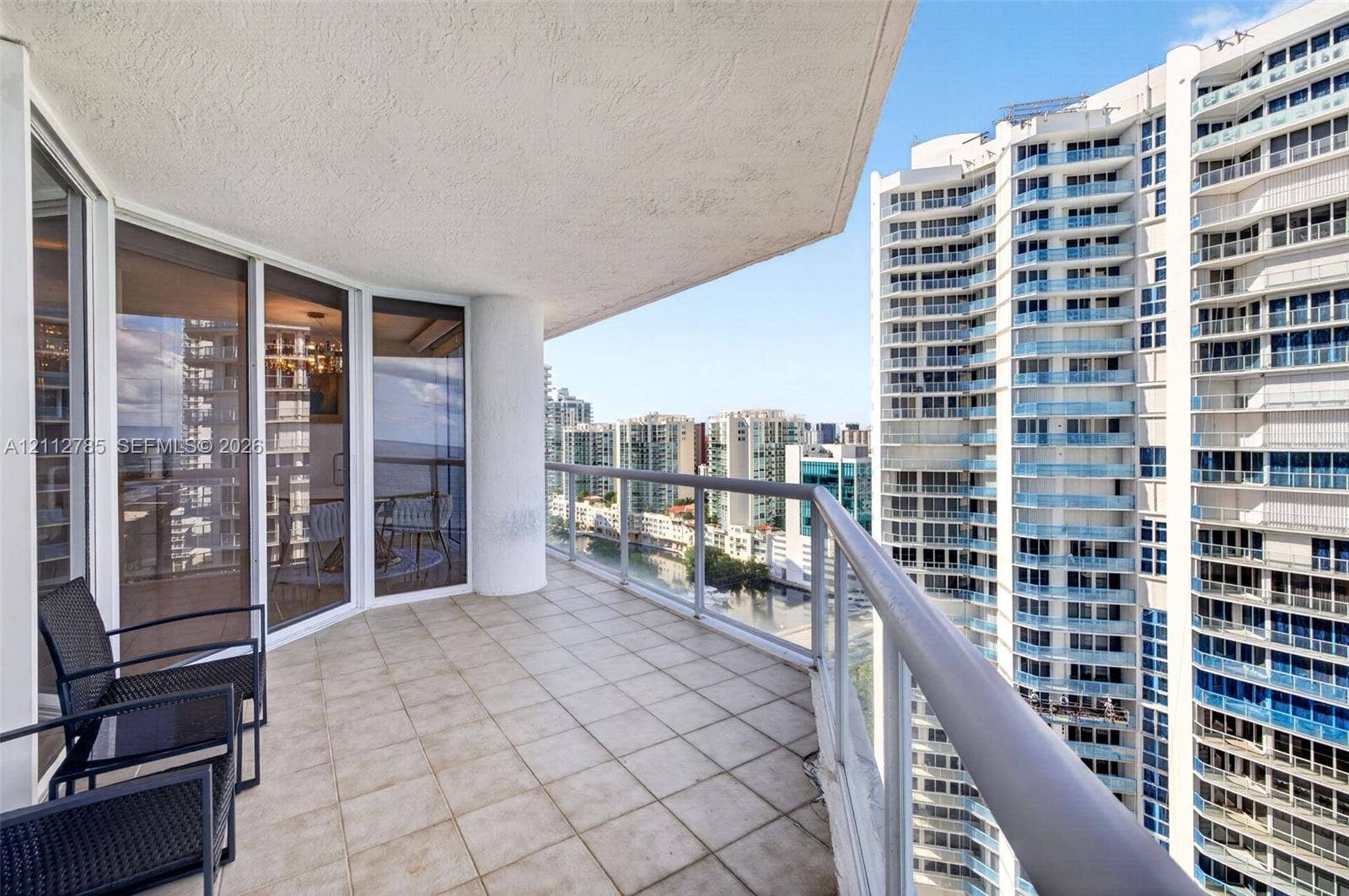 16425 Collins Avenue, #2016, Sunny Isles Beach, FL 33160 Covered wrap-around balcony featuring ceramic tile flooring, a metal-framed glass railing, and floor-to-ceiling glass sliding doors
