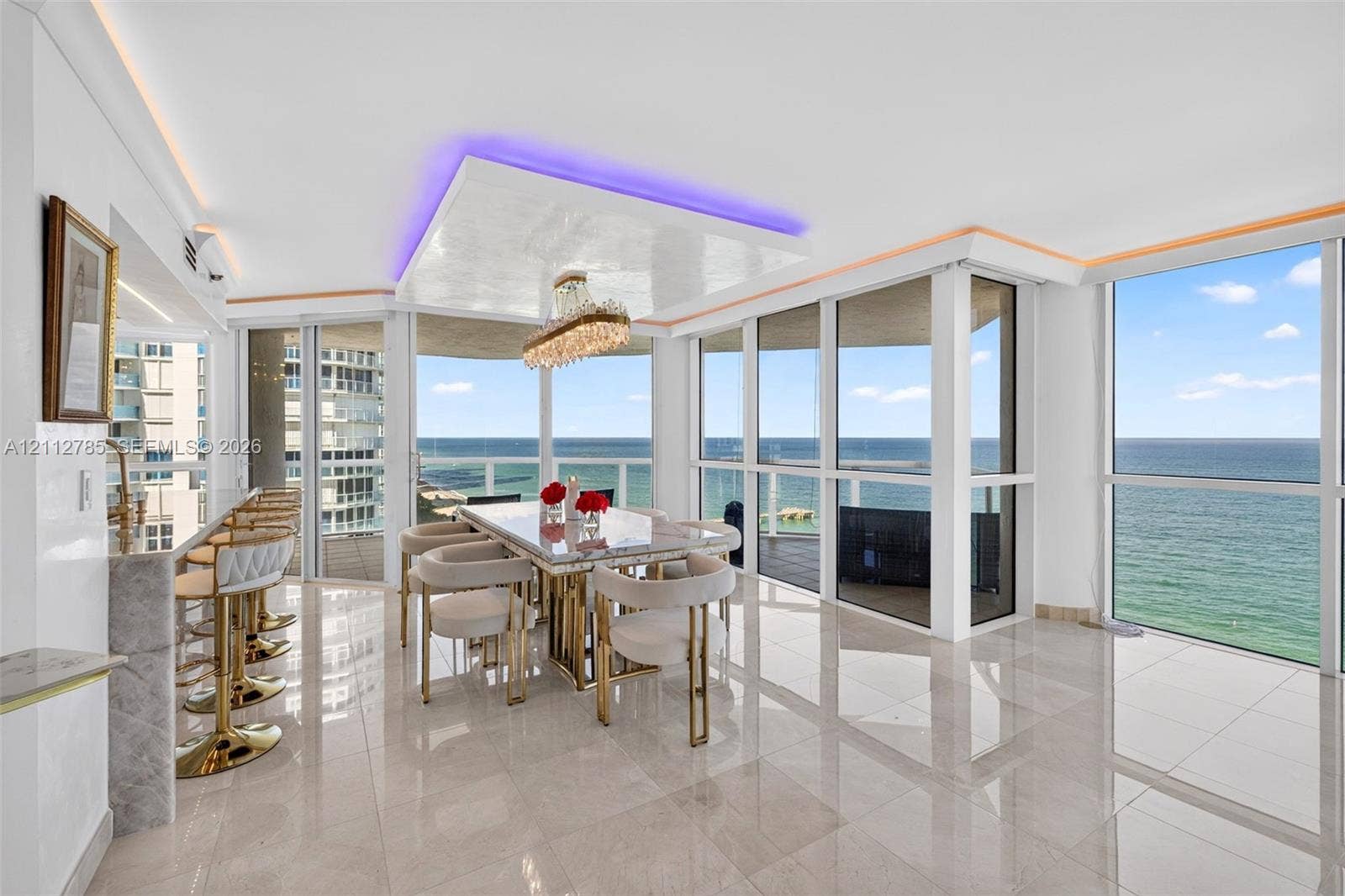 16425 Collins Avenue, #2016, Sunny Isles Beach, FL 33160 Open-concept area featuring polished stone-finish flooring, floor-to-ceiling glass windows, recessed ceiling lighting with perimeter accent detailing, and an integrated stone-finish breakfast bar