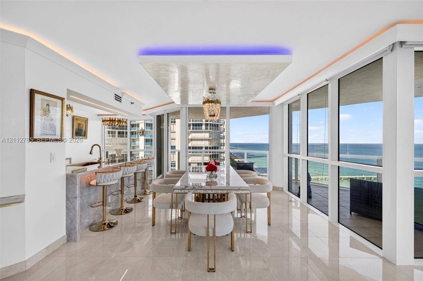 16425 Collins Avenue, #2016, Sunny Isles Beach, FL 33160 Floor-to-ceiling windows with ocean exposure, polished stone flooring, custom coffered ceiling with integrated accent lighting, wet bar with stone-surround, and a crystal chandelier