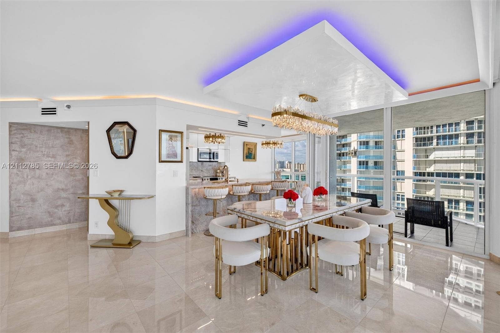 16425 Collins Avenue, #2016, Sunny Isles Beach, FL 33160 Open-concept area featuring polished tile flooring, a recessed ceiling detail with integrated accent lighting, a large crystal-style linear chandelier, and floor-to-ceiling glass windows