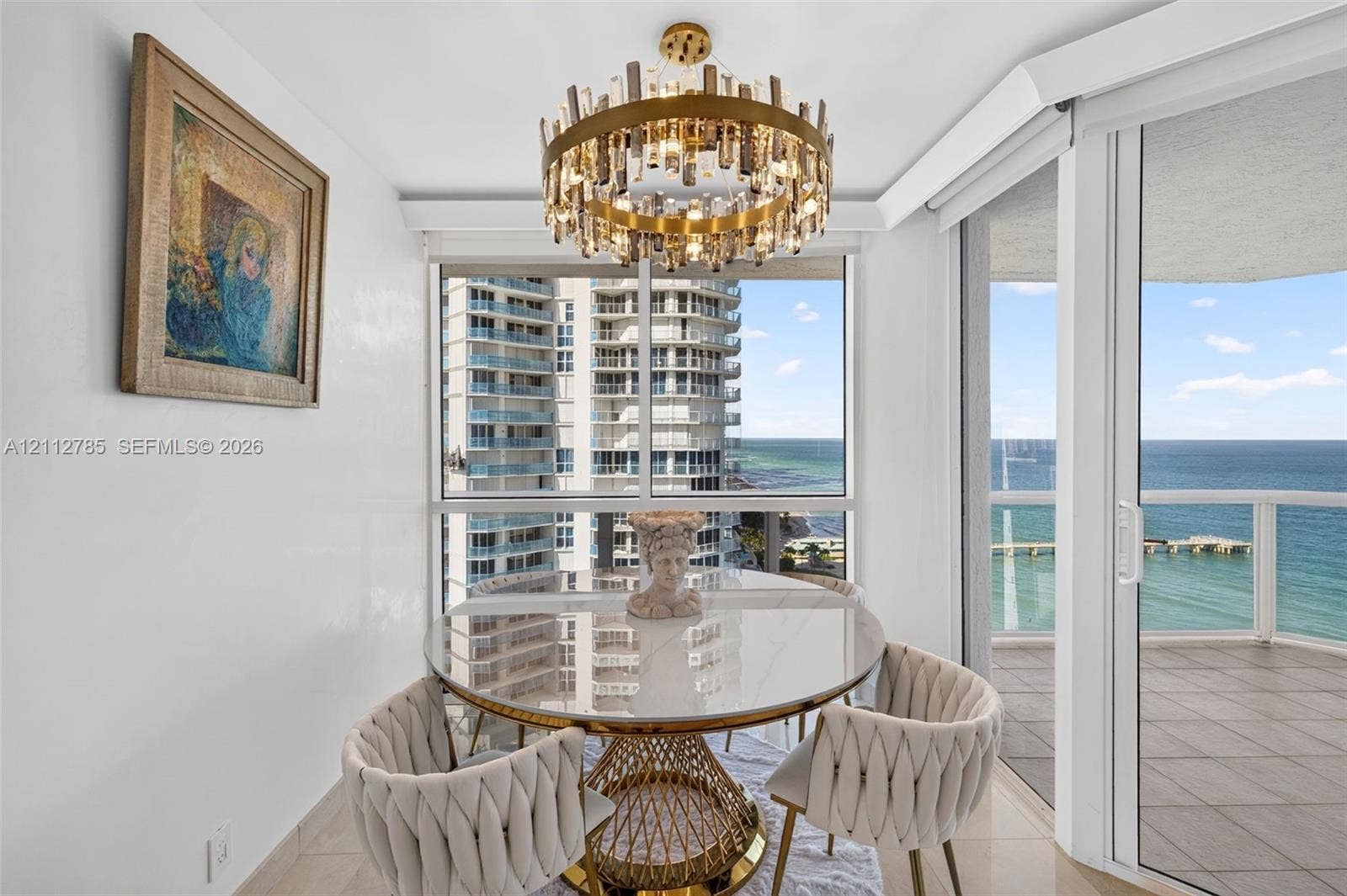 16425 Collins Avenue, #2016, Sunny Isles Beach, FL 33160 Circular chandelier with tiered crystal detailing, floor-to-ceiling windows, sliding glass door, and tile flooring