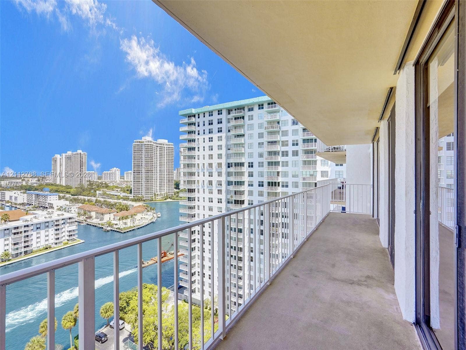 Covered balcony featuring concrete flooring and a full-height white metal railing