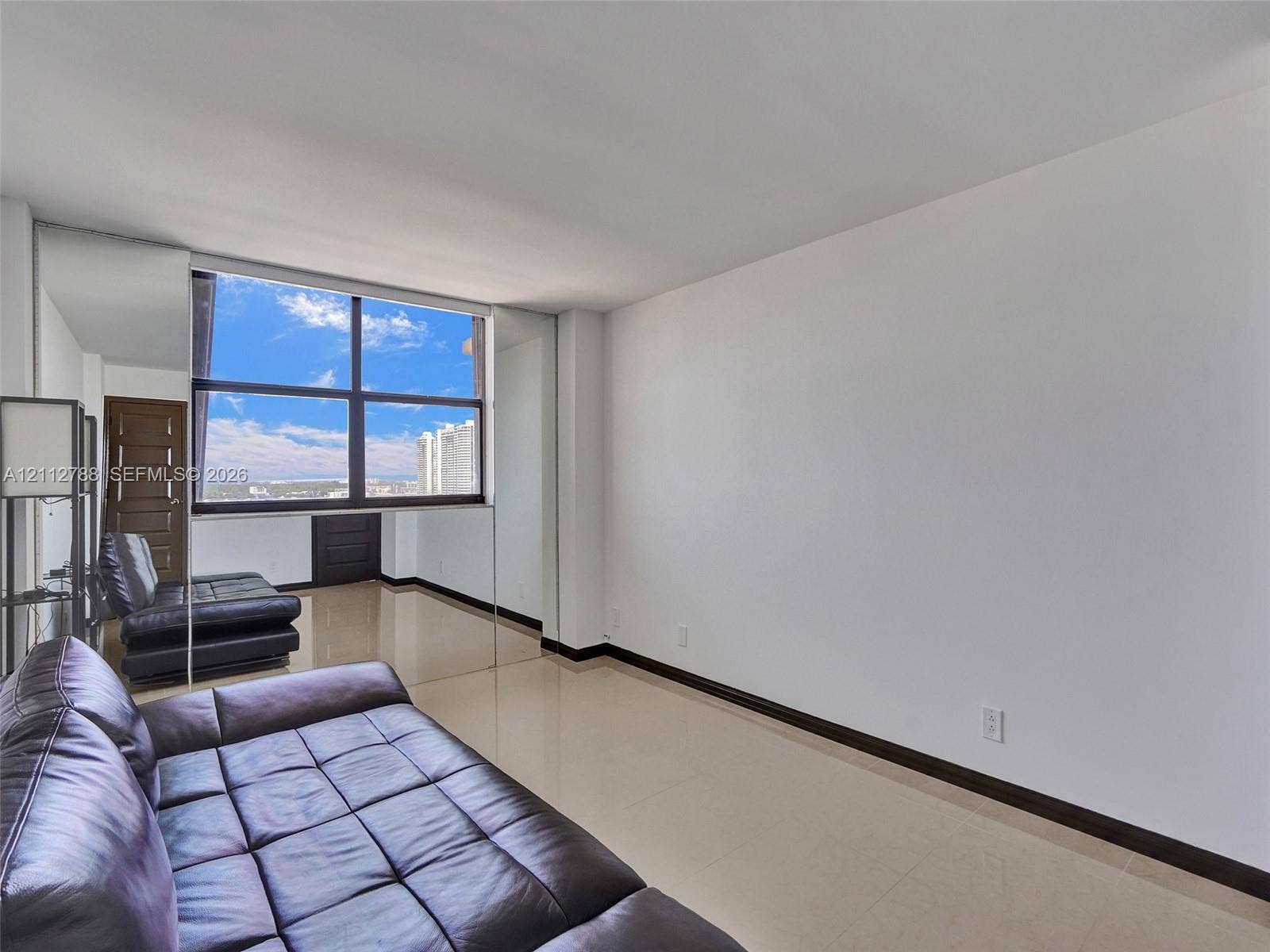 Expansive, multi-pane window with exterior scenery, polished tile flooring, and mirrored wall panels