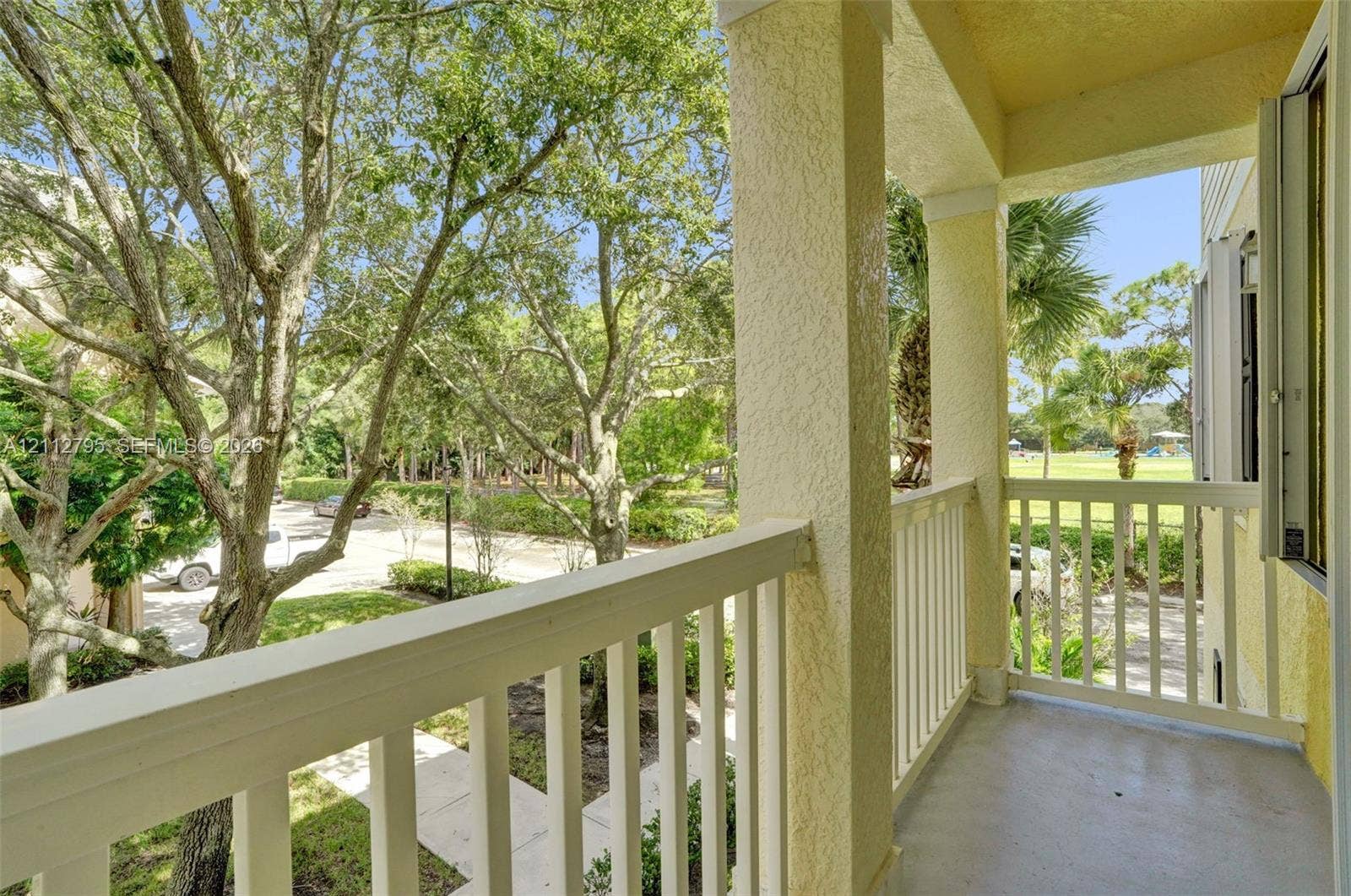 275 Murcia Drive, #205, Jupiter, FL 33458 Covered balcony featuring white vertical railings, stucco columns, and concrete flooring