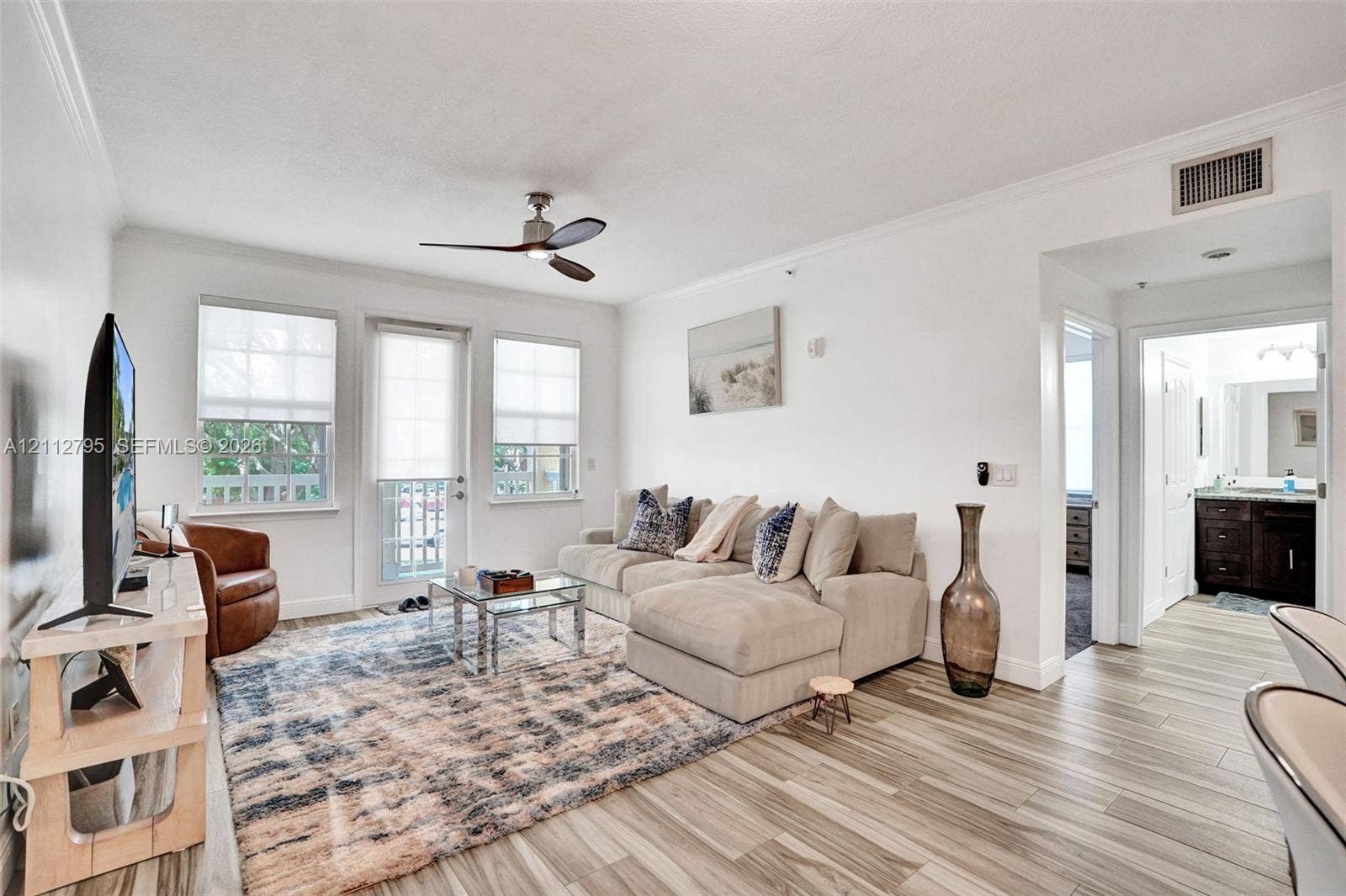 275 Murcia Drive, #205, Jupiter, FL 33458 Living area featuring wood-finish flooring, ceiling fan, and access to an exterior balcony