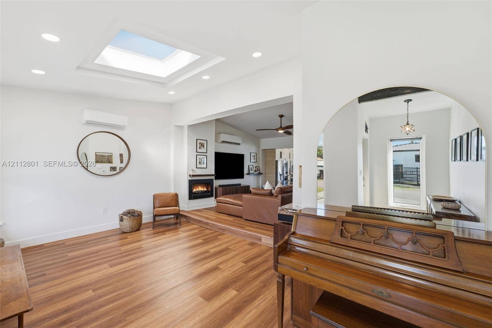 3241 SW 84th Court, Miami, FL 33155 Open-concept living space featuring wood-finish flooring, a recessed ceiling skylight, recessed lighting, and an inset fireplace