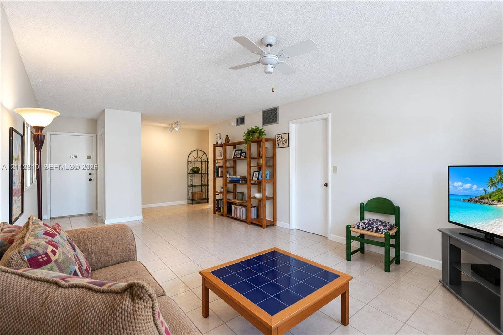 1920 NE 1st Terrace, #107H, Wilton Manors, FL 33305 Open floor plan featuring neutral-tone ceramic tile flooring, ceiling fan, and crisp white walls
