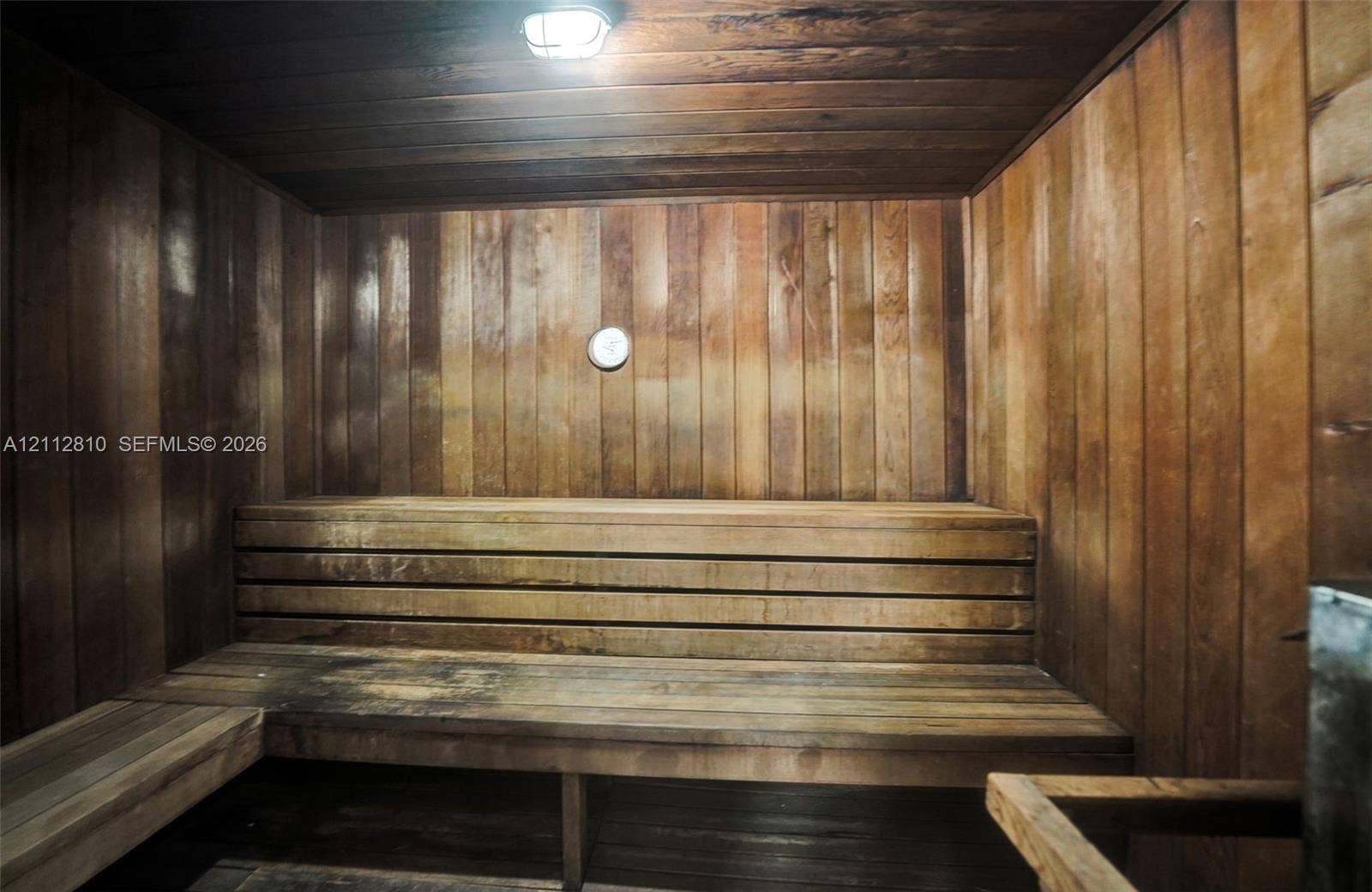1920 NE 1st Terrace, #107H, Wilton Manors, FL 33305 Sauna featuring cedar paneling, multi-level wooden bench seating, and overhead lighting