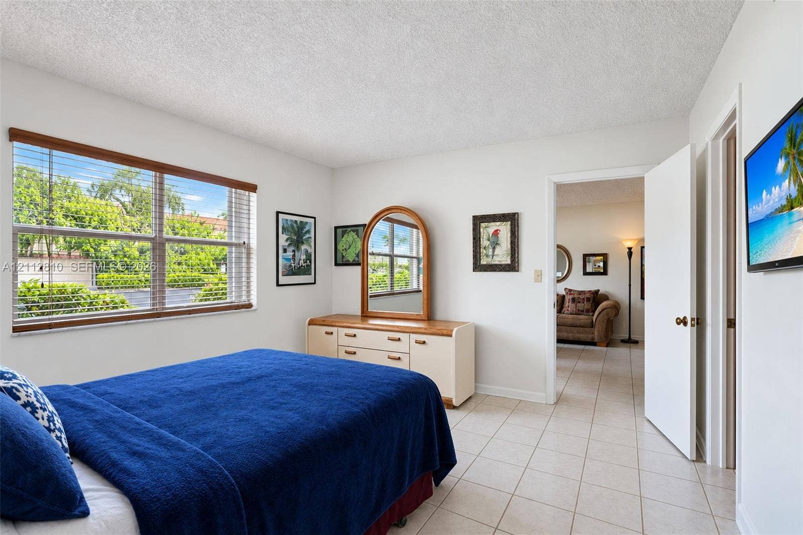 1920 NE 1st Terrace, #107H, Wilton Manors, FL 33305 Large horizontal window with wood-finish blinds, neutral ceramic tile flooring, and textured ceiling finish