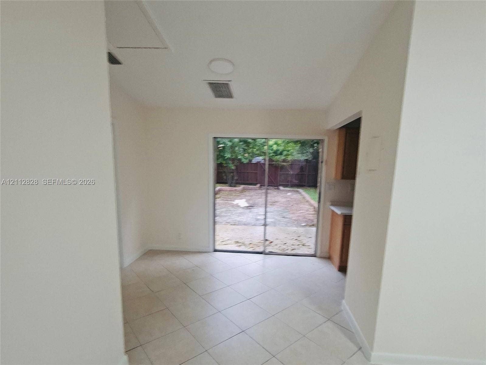 508 NW 43rd Place, Deerfield Beach, FL 33064 Tile flooring, sliding glass door, and a concrete rear patio