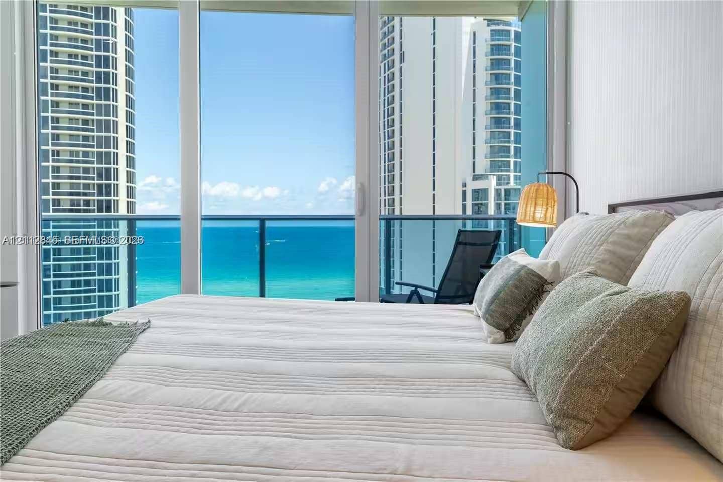 17550 Collins Avenue, #1202, Sunny Isles Beach, Sunny Isles Beach, FL 33160 Floor-to-ceiling glass paneling featuring ocean and high-rise cityscape backdrops, with access to a private balcony enclosed by glass and metal railing