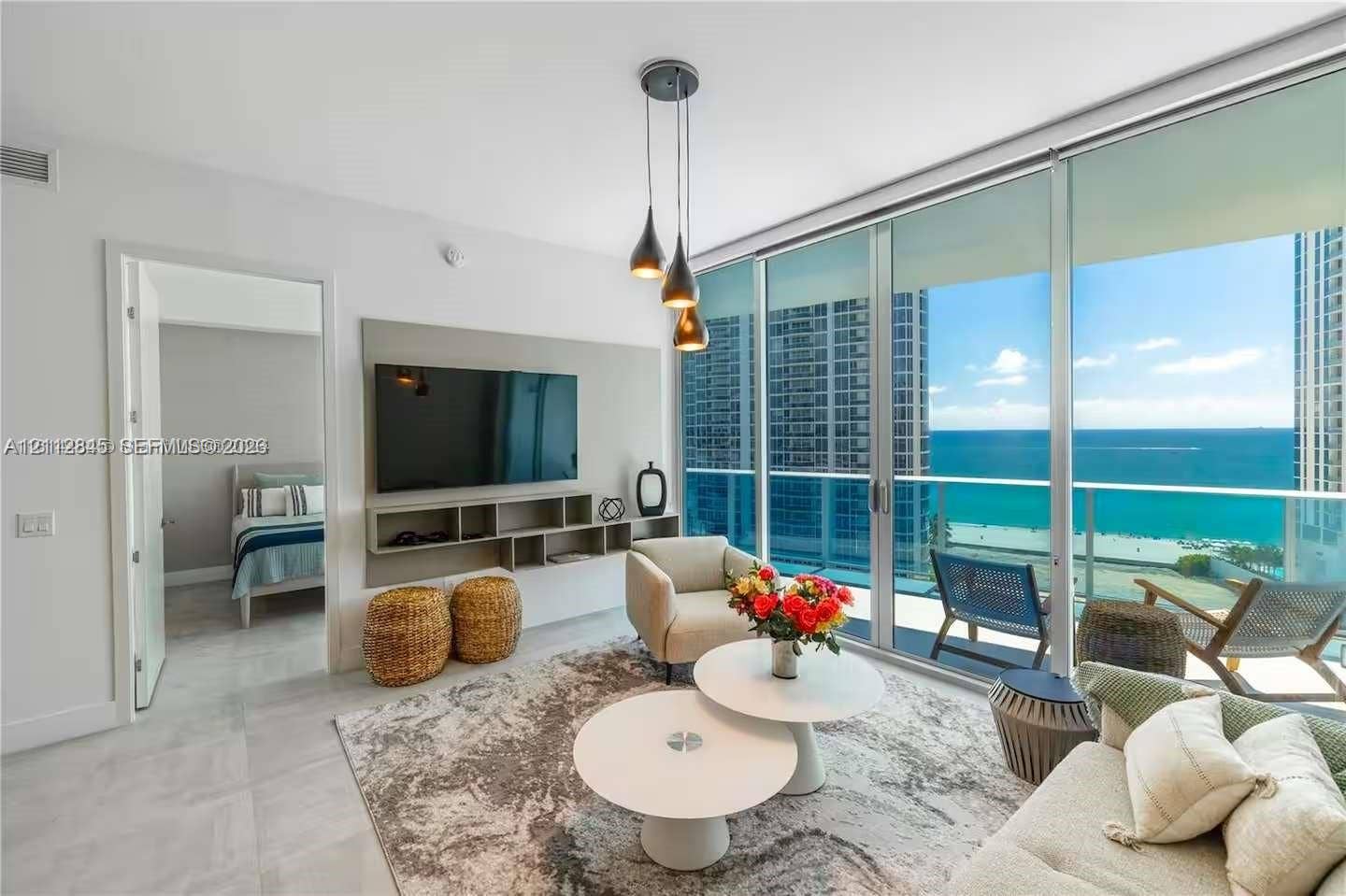 17550 Collins Avenue, #1202, Sunny Isles Beach, Sunny Isles Beach, FL 33160 Floor-to-ceiling windows with oceanfront exposure, custom built-in media shelving, pendant lighting, and large-format tile flooring