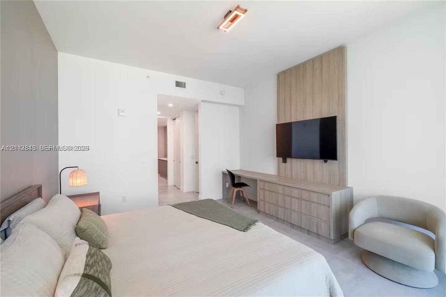 17550 Collins Avenue, #1202, Sunny Isles Beach, Sunny Isles Beach, FL 33160 Custom floor-to-ceiling wood-finish wall paneling, integrated built-in cabinetry, streamlined desk workstation, and modern rectangular flush-mount ceiling lighting