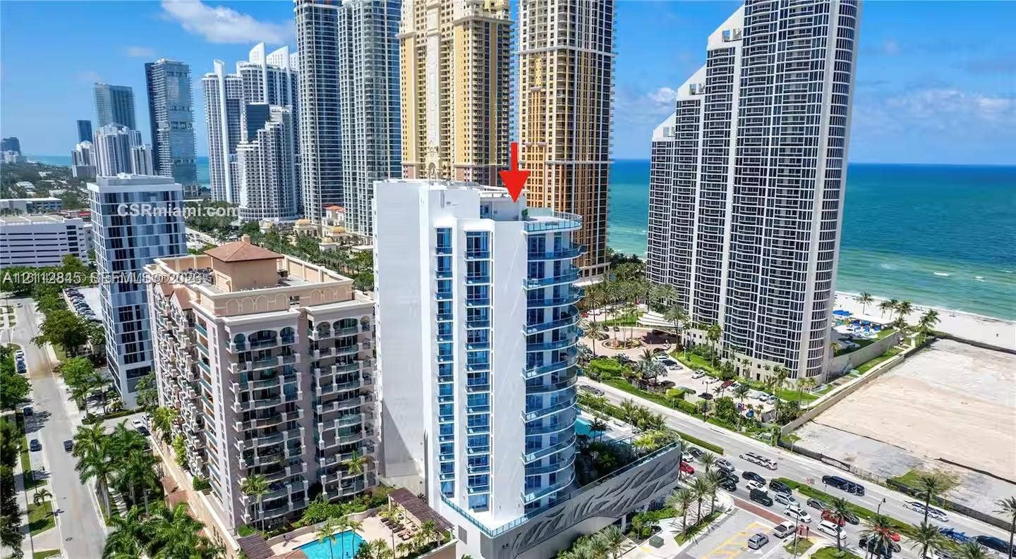 17550 Collins Avenue, #1202, Sunny Isles Beach, Sunny Isles Beach, FL 33160 High-rise residential tower featuring blue glass-panel balconies, concrete facade, and proximity to the coastline