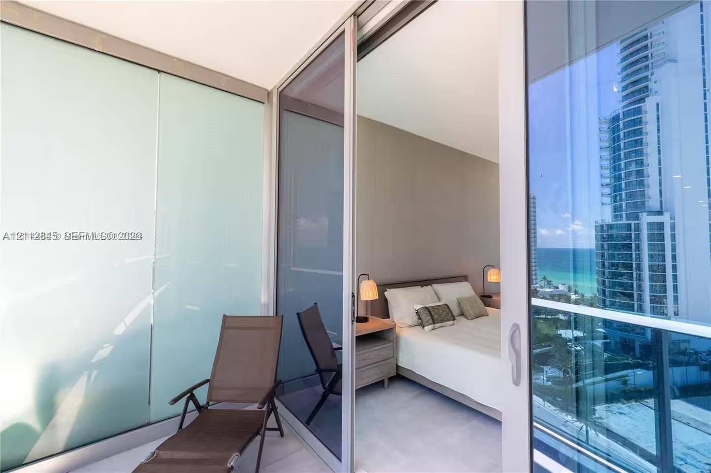 17550 Collins Avenue, #1202, Sunny Isles Beach, Sunny Isles Beach, FL 33160 Private balcony featuring floor-to-ceiling glass paneling, tile flooring, and sliding glass door access