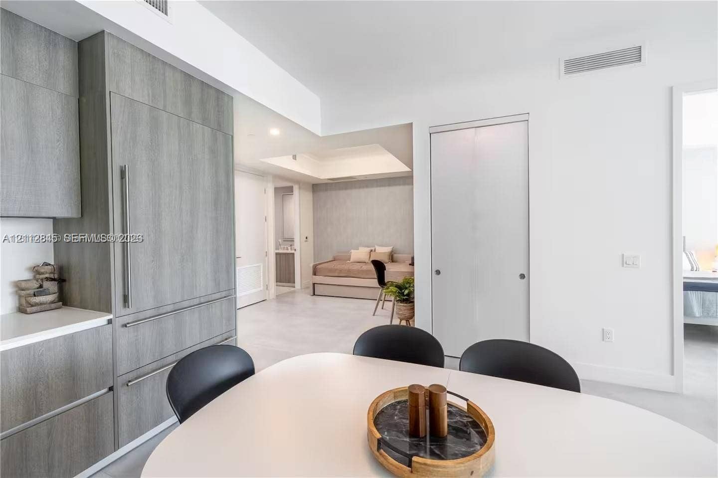 17550 Collins Avenue, #1202, Sunny Isles Beach, Sunny Isles Beach, FL 33160 Modern kitchen cabinetry with wood-finish paneling, integrated refrigerator, white stone countertops, and tile flooring