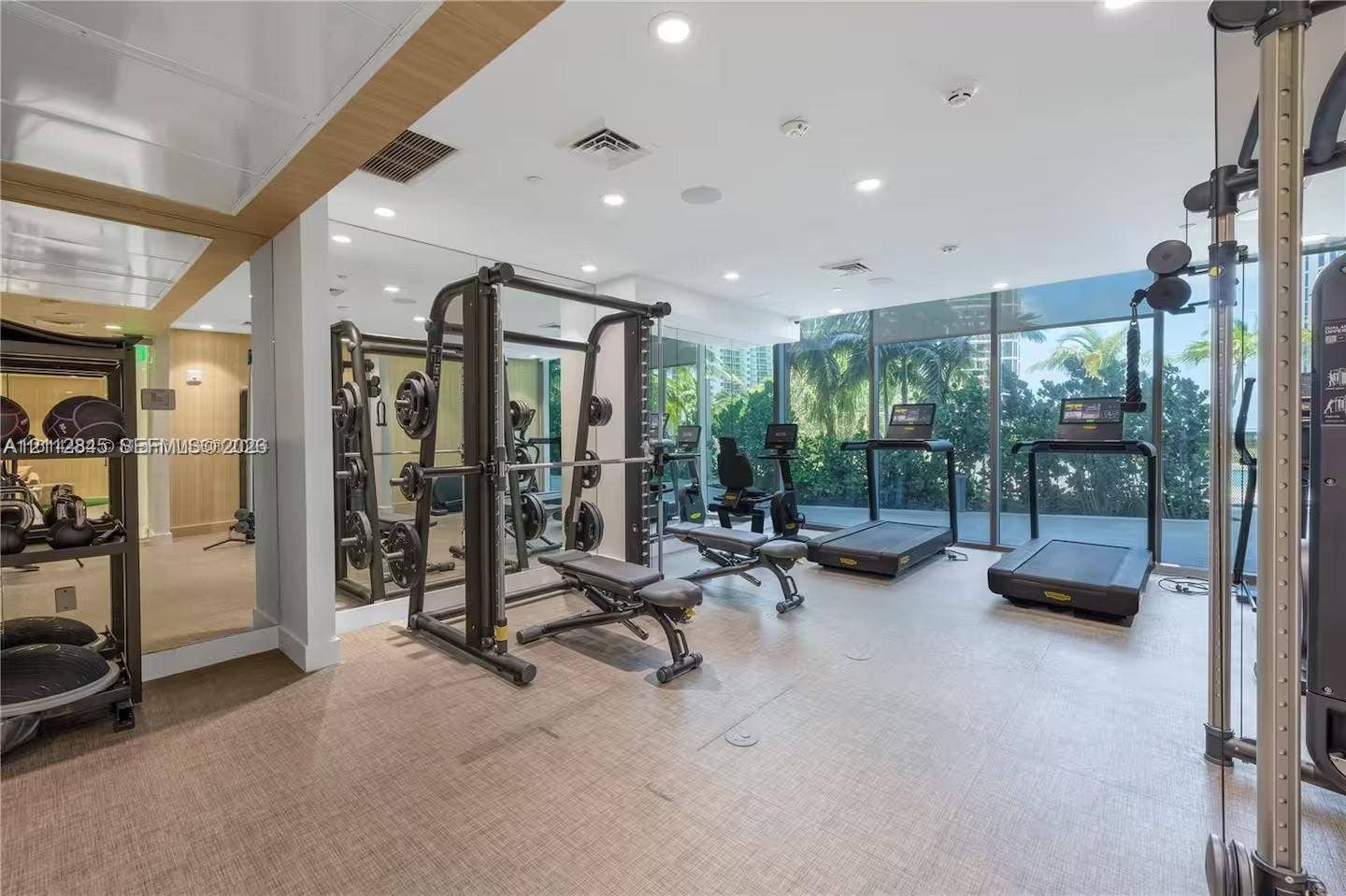 17550 Collins Avenue, #1202, Sunny Isles Beach, Sunny Isles Beach, FL 33160 Fitness center featuring floor-to-ceiling windows, full-wall mirrors, recessed lighting, and resilient textured flooring