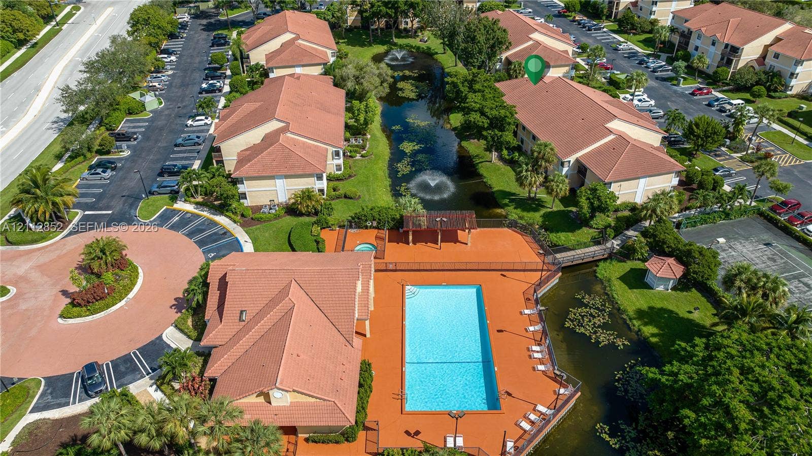 5741 Riverside Drive, #205A5, Coral Springs, Coral Springs, FL 33067 Aerial perspective of a multi-unit complex featuring a swimming pool, spa, pond with fountain features, and landscaped grounds