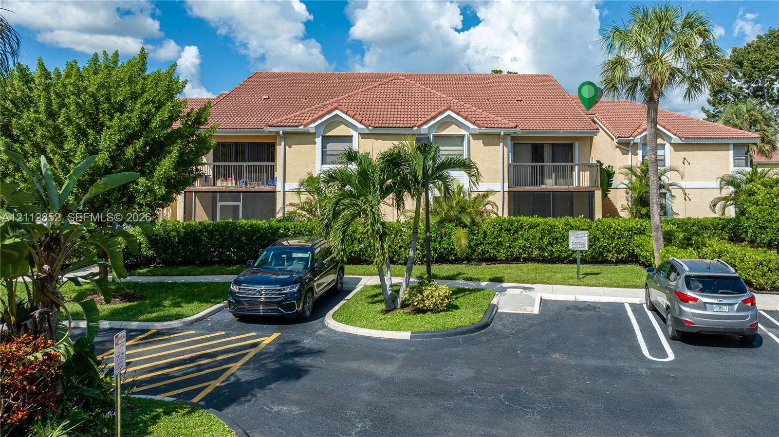 5741 Riverside Drive, #205A5, Coral Springs, Coral Springs, FL 33067 Multi-family exterior featuring a terracotta-tiled roof, private second-story balconies, and landscaped grounds with mature palm trees