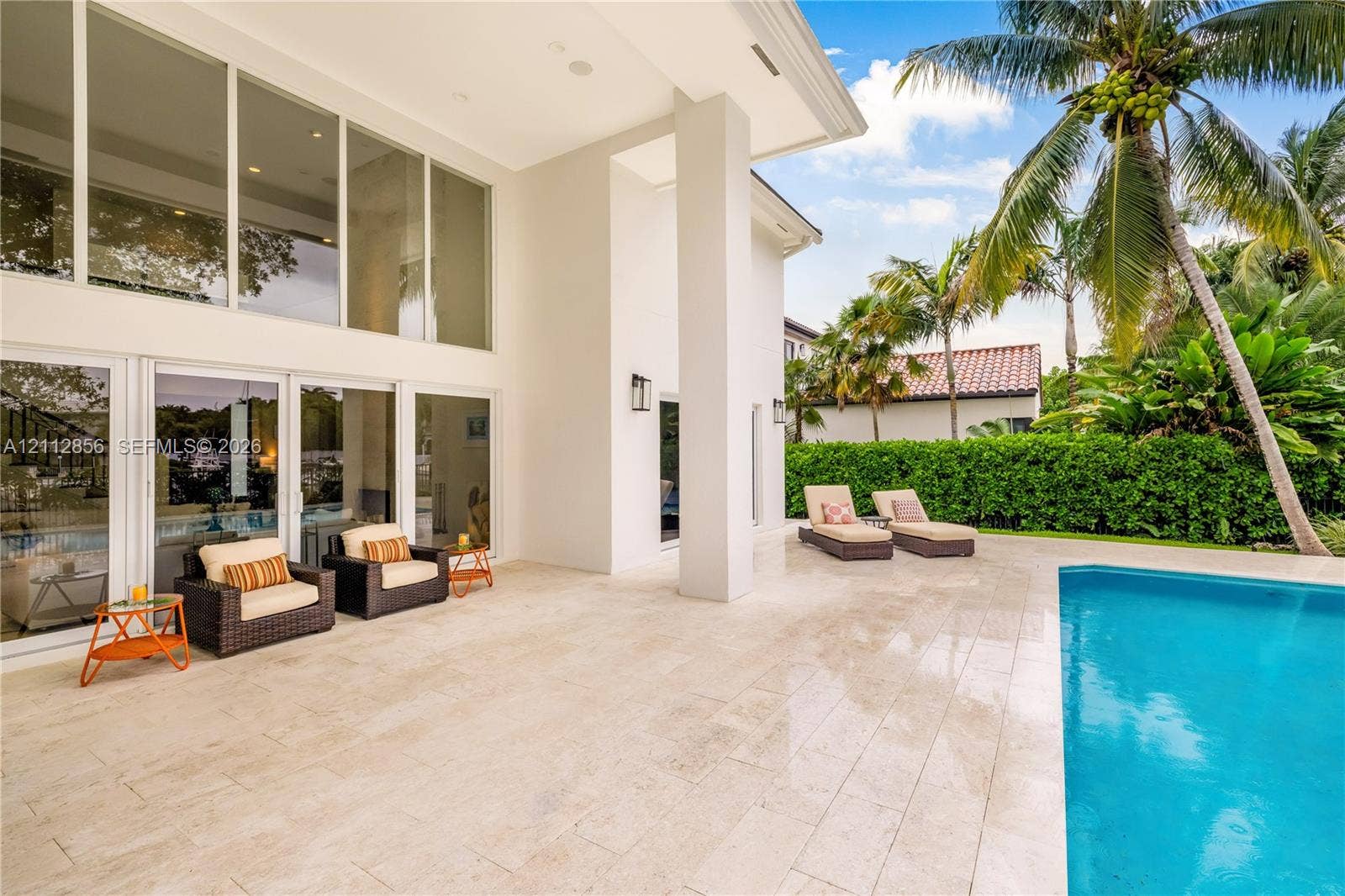 285 Las Brisas Court, Coral Gables, FL 33143 Covered patio featuring floor-to-ceiling glass paneling, stone-tile flooring, and a swimming pool