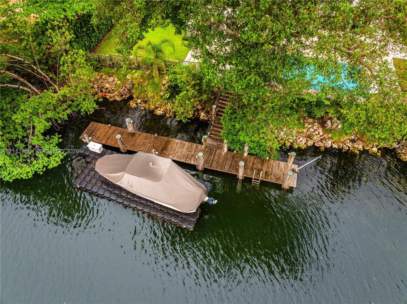 285 Las Brisas Court, Coral Gables, FL 33143 Private wooden dock featuring a fixed pier, integrated ladder, and a modular floating boat lift