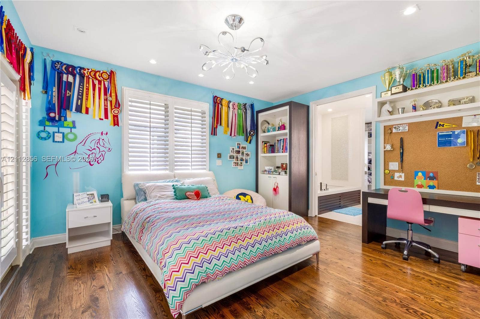 285 Las Brisas Court, Coral Gables, FL 33143 Hardwood flooring, multi-tier decorative ceiling light fixture, plantation shutters, built-in floor-to-ceiling cabinetry, and integrated desk with overhead shelving