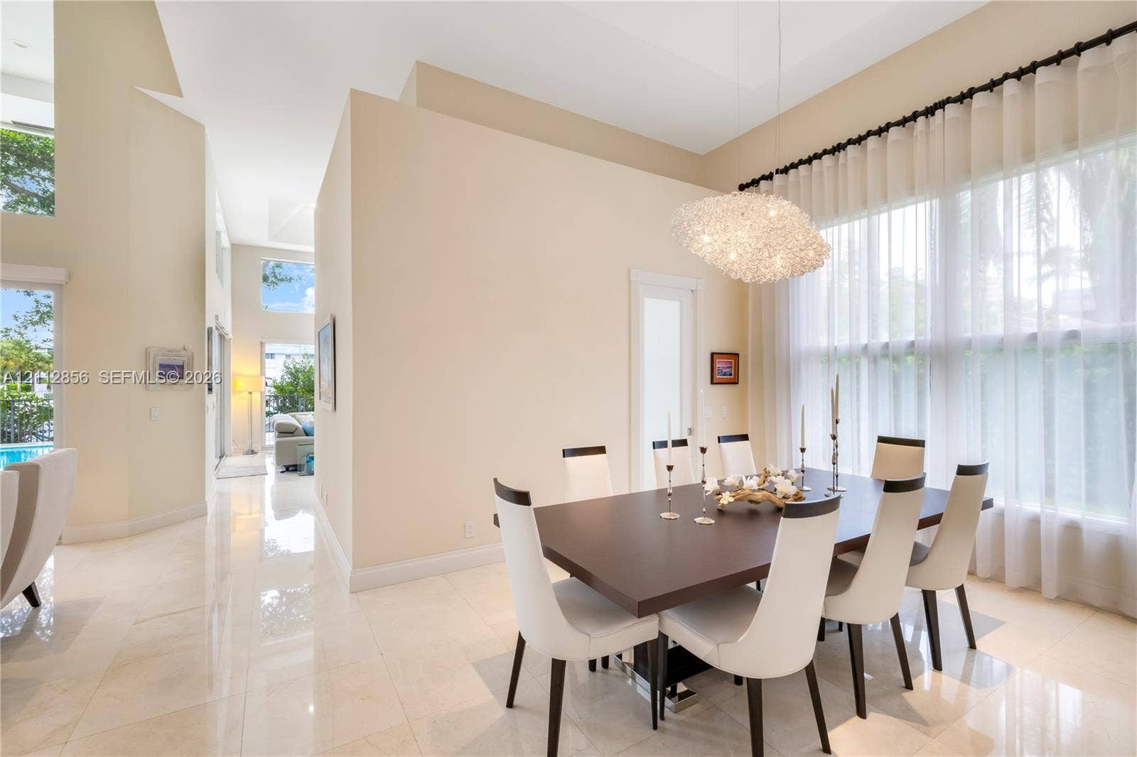 285 Las Brisas Court, Coral Gables, FL 33143 High ceilings, polished stone flooring, custom architectural pendant lighting, and oversized windows with drapery