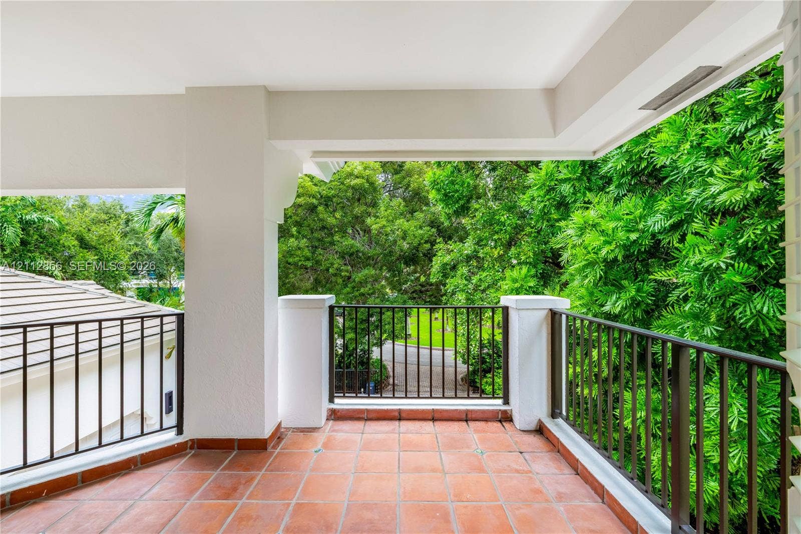285 Las Brisas Court, Coral Gables, FL 33143 Covered terrace featuring terra cotta tile flooring, metal railing, and concrete pillars