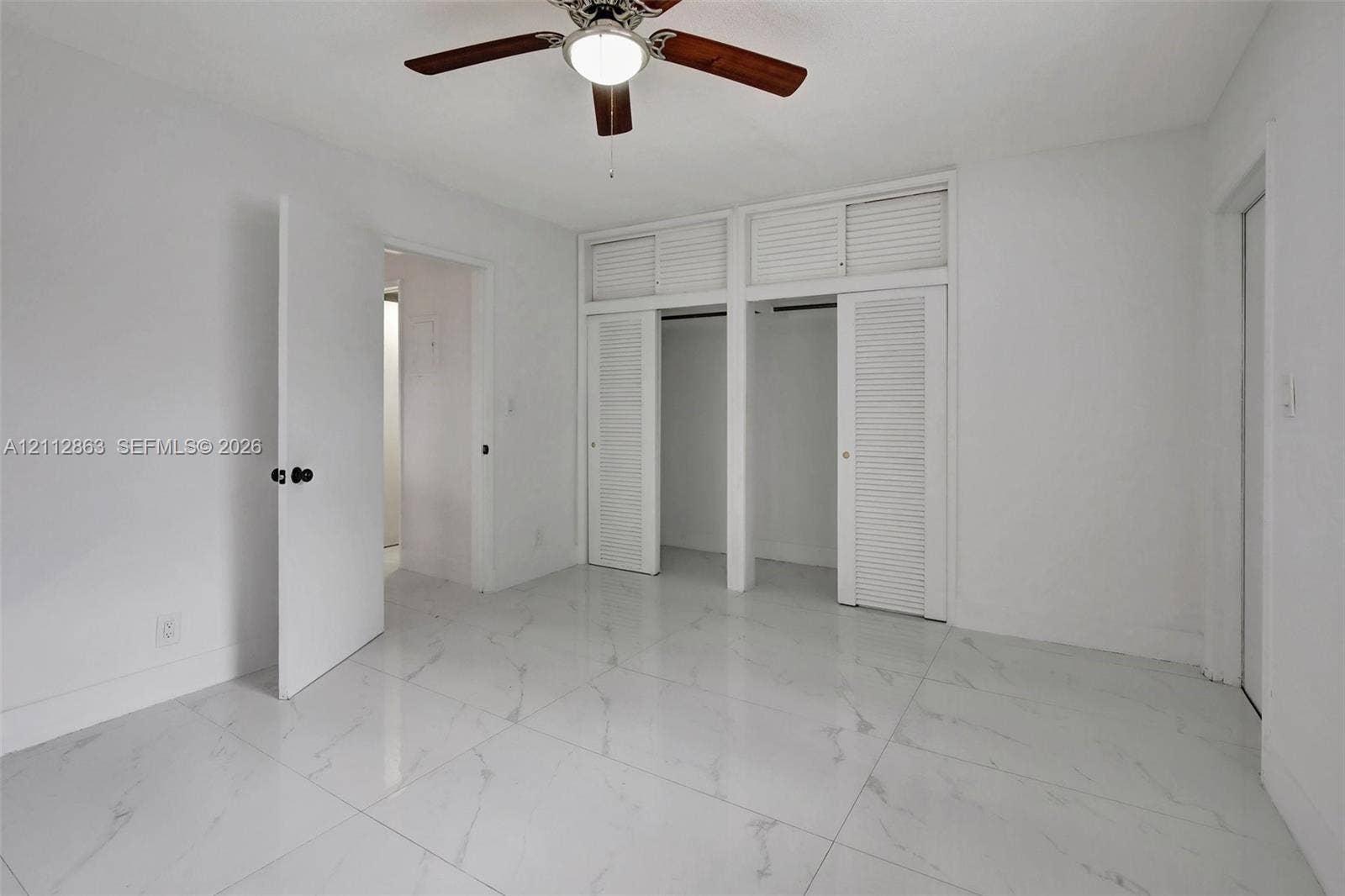 1520 NE 56th Street, #4, Fort Lauderdale, Fort Lauderdale, FL 33334 Polished stone-finish flooring, ceiling fan with light fixture, and dual reach-in closets featuring louvered doors with overhead storage compartments
