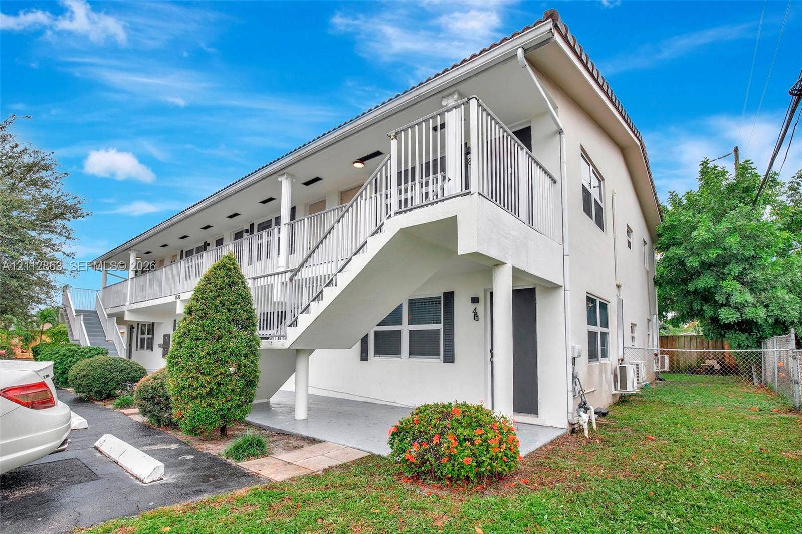 1520 NE 56th Street, #4, Fort Lauderdale, Fort Lauderdale, FL 33334 Two-story stucco exterior featuring a tiled roof, metal staircase, and an elevated balcony with a metal railing