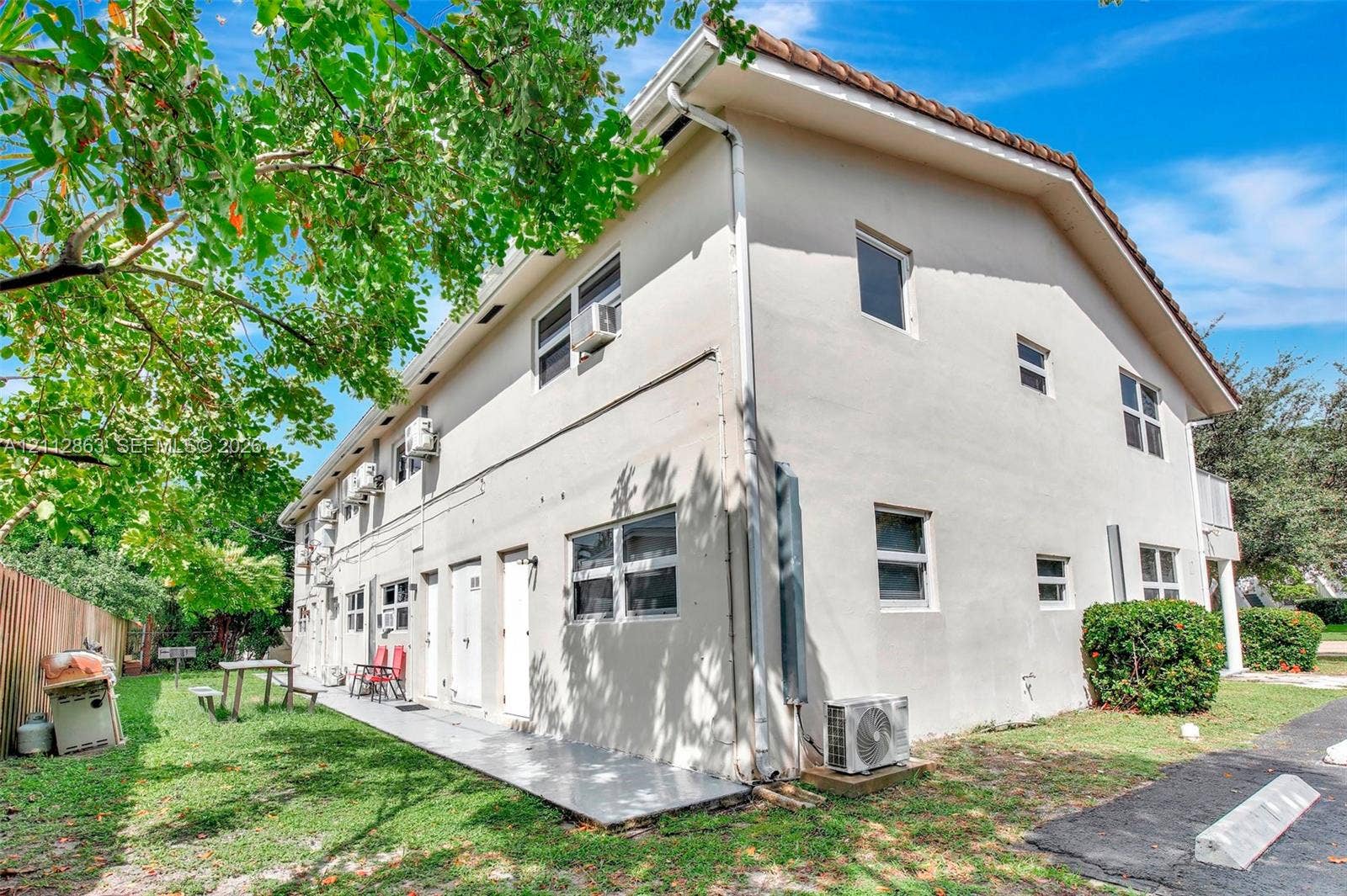 1520 NE 56th Street, #4, Fort Lauderdale, Fort Lauderdale, FL 33334 Multi-story stucco exterior featuring a gabled roofline, multiple windows, and a paved exterior walkway