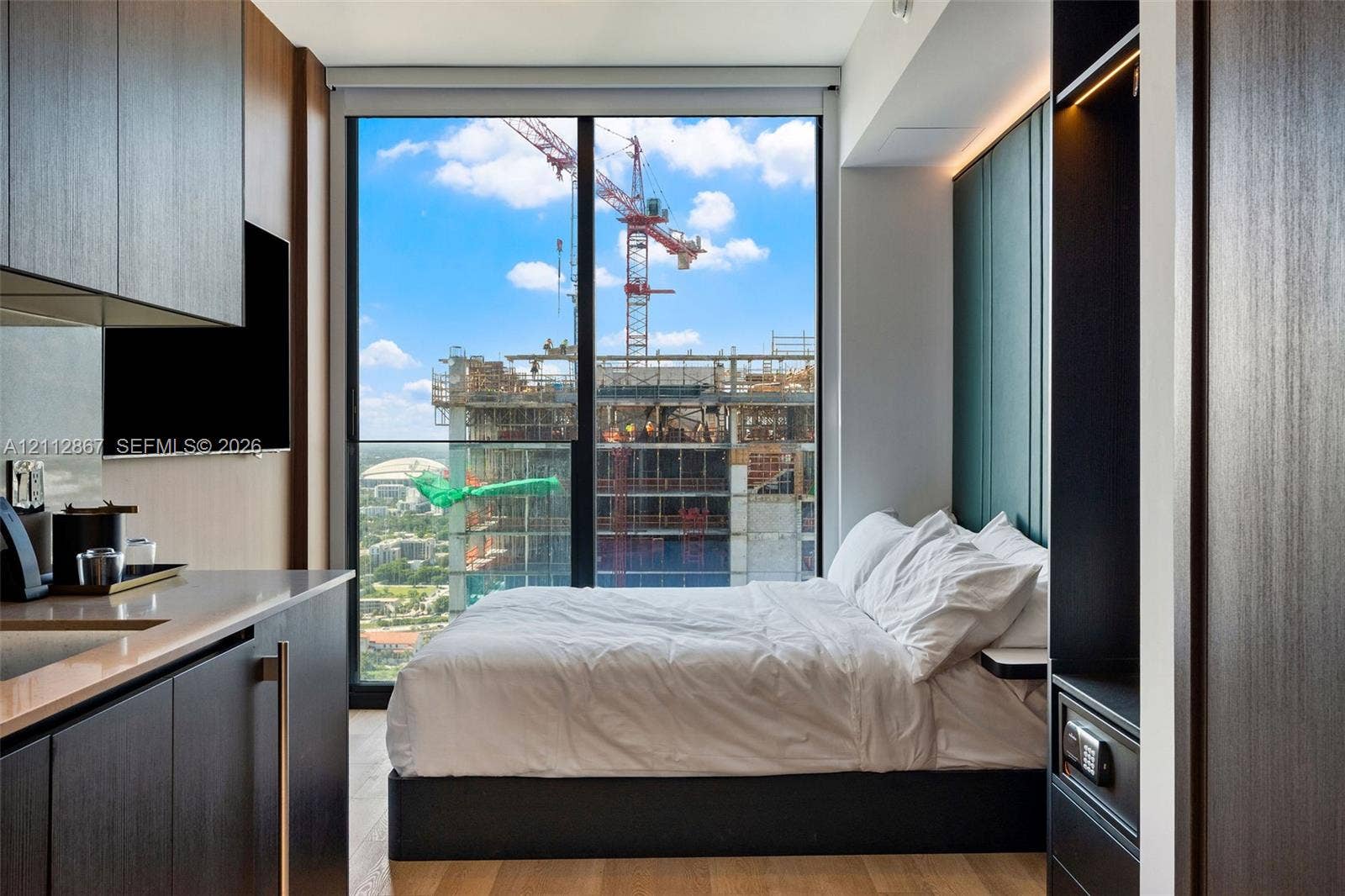 Floor-to-ceiling windows, built-in dark wood-finish cabinetry, wood-finish flooring, and recessed accent lighting