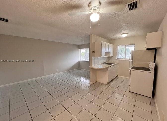 2150 Madison Street, #26, Hollywood, Hollywood, FL 33020 Kitchen featuring white cabinetry, a peninsula counter, and tile flooring throughout